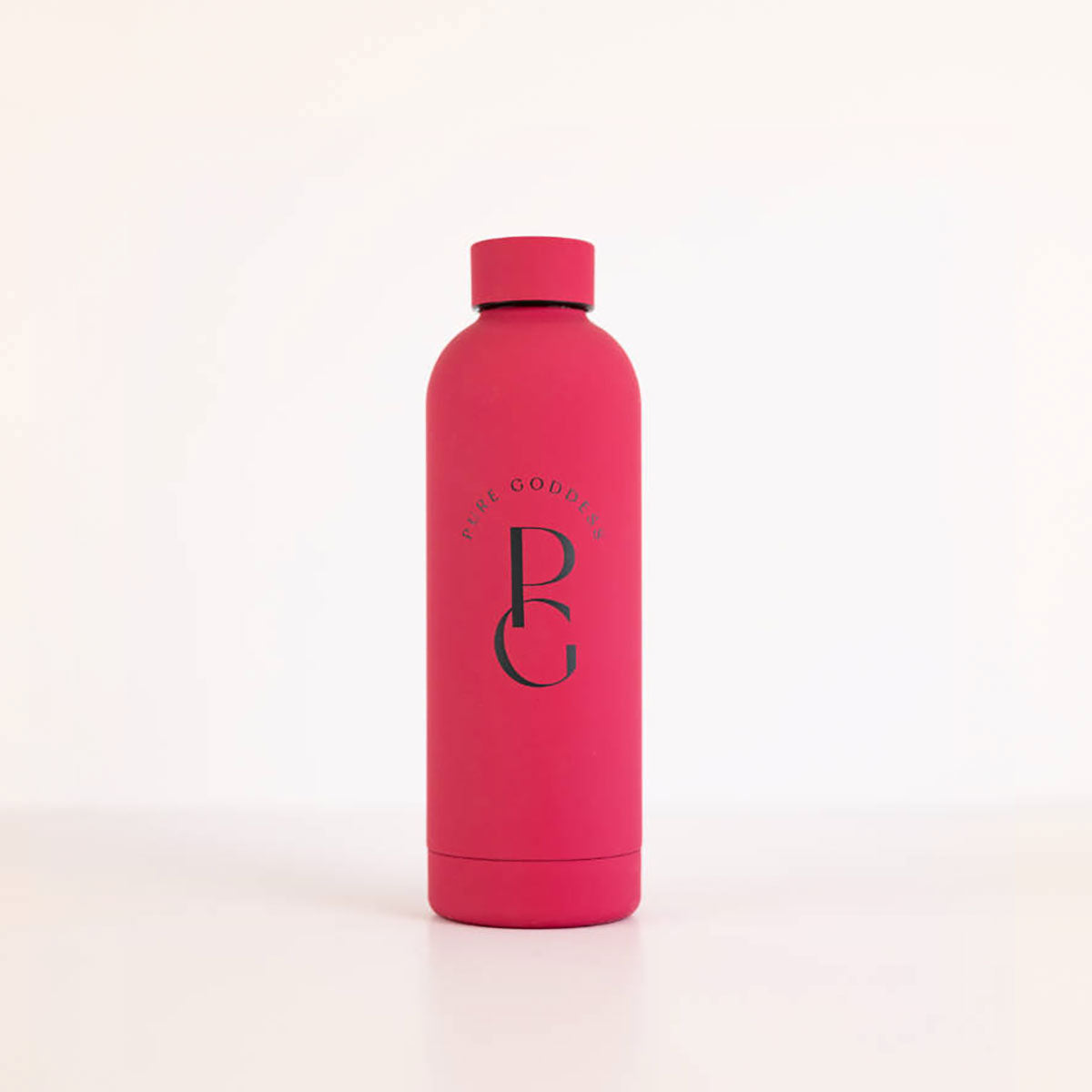 A pink satin-finish metal water bottle with the Pure Goddess logo embossed on the front, including a screw top lid.