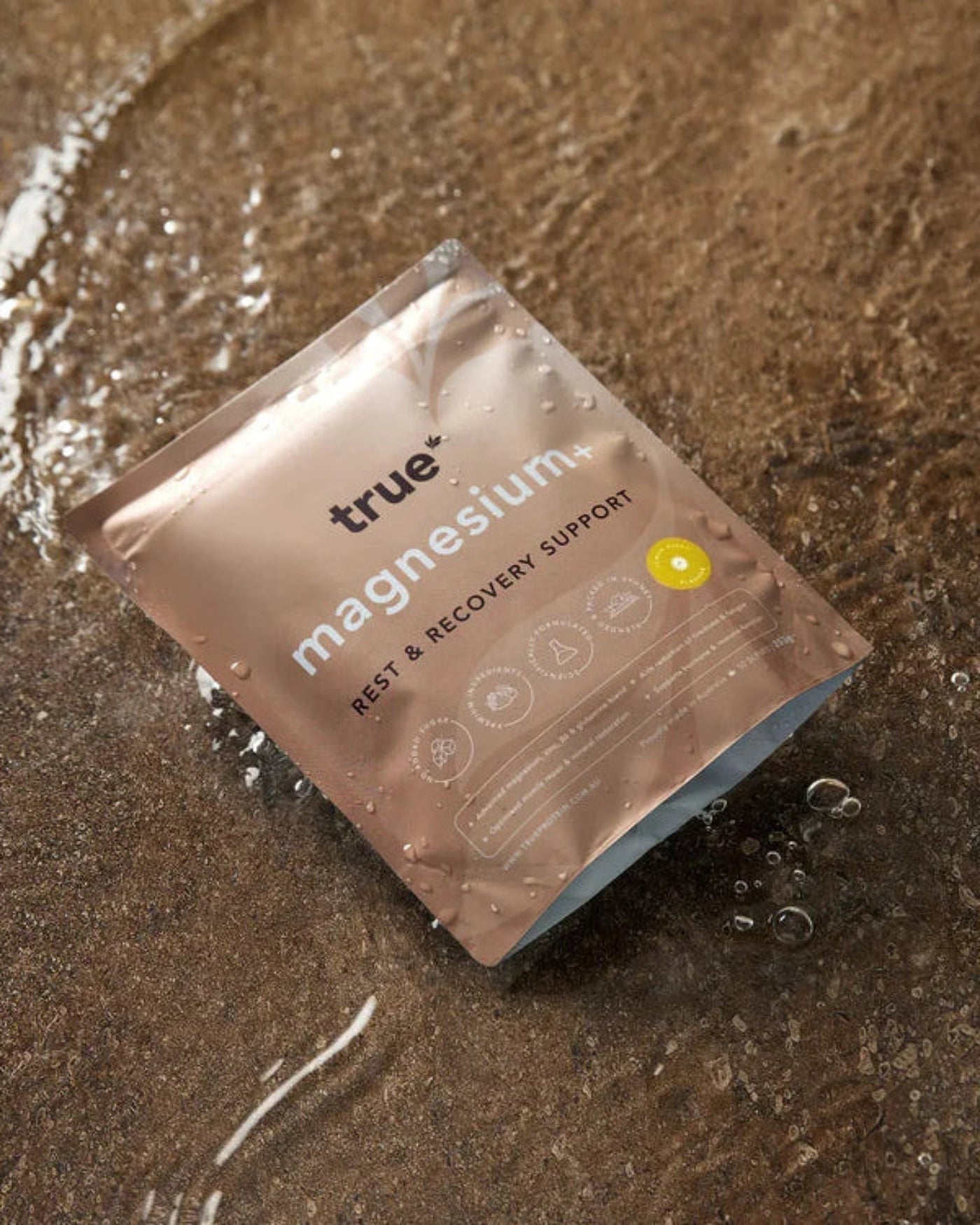 True Magnesium supplement packet on a wet surface